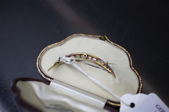 An early 20th century gold and silver, graduated white opal crescent brooch, 2in.